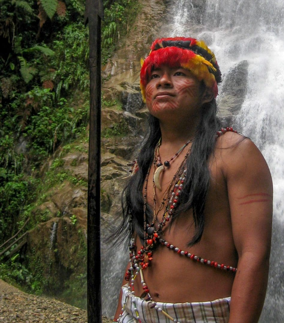 Hombre Shuar frente a una cascada